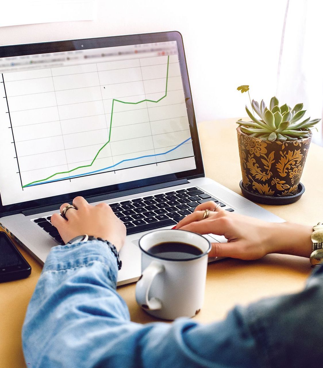 A person is viewing analytics of their evergreen content next to a cup of coffee