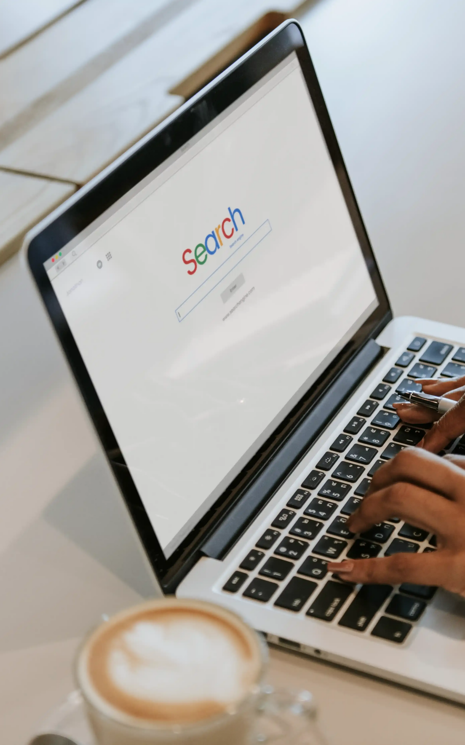 Person typing on a laptop with Google search open, wanting to know more about SEO and how much it costs.