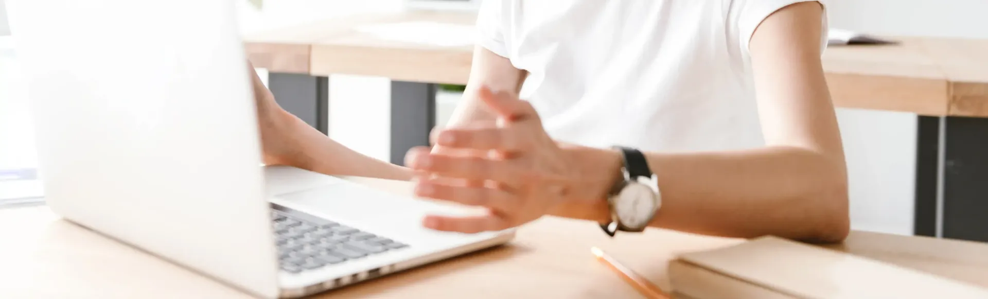 A woman is sitting at a desk using a laptop computer for career coaching.