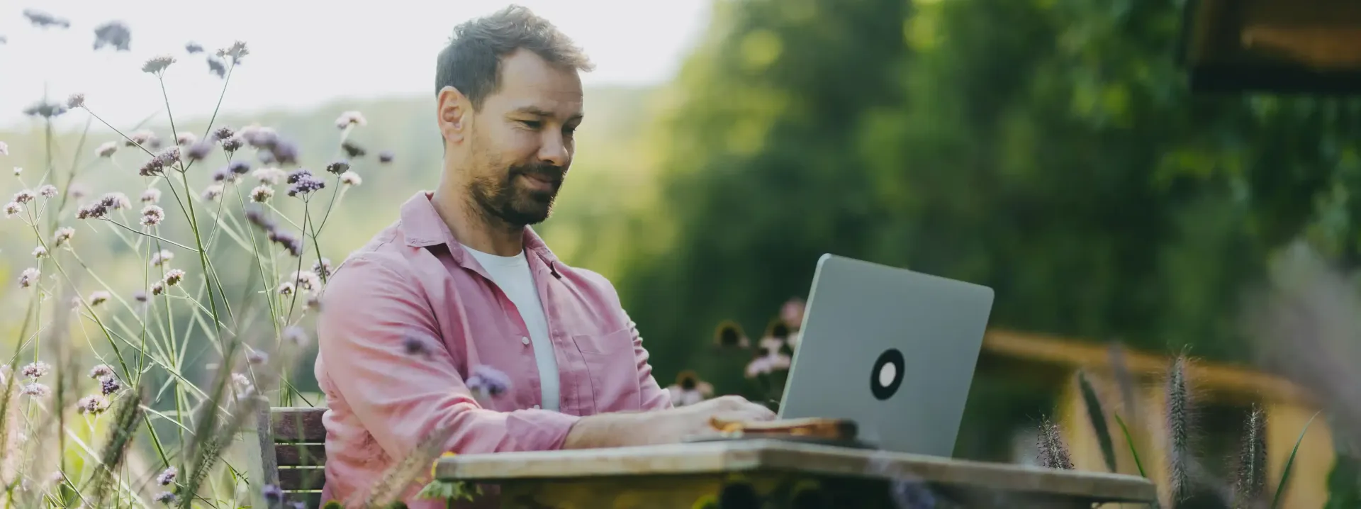 A man is sitting at a table using a laptop computer.