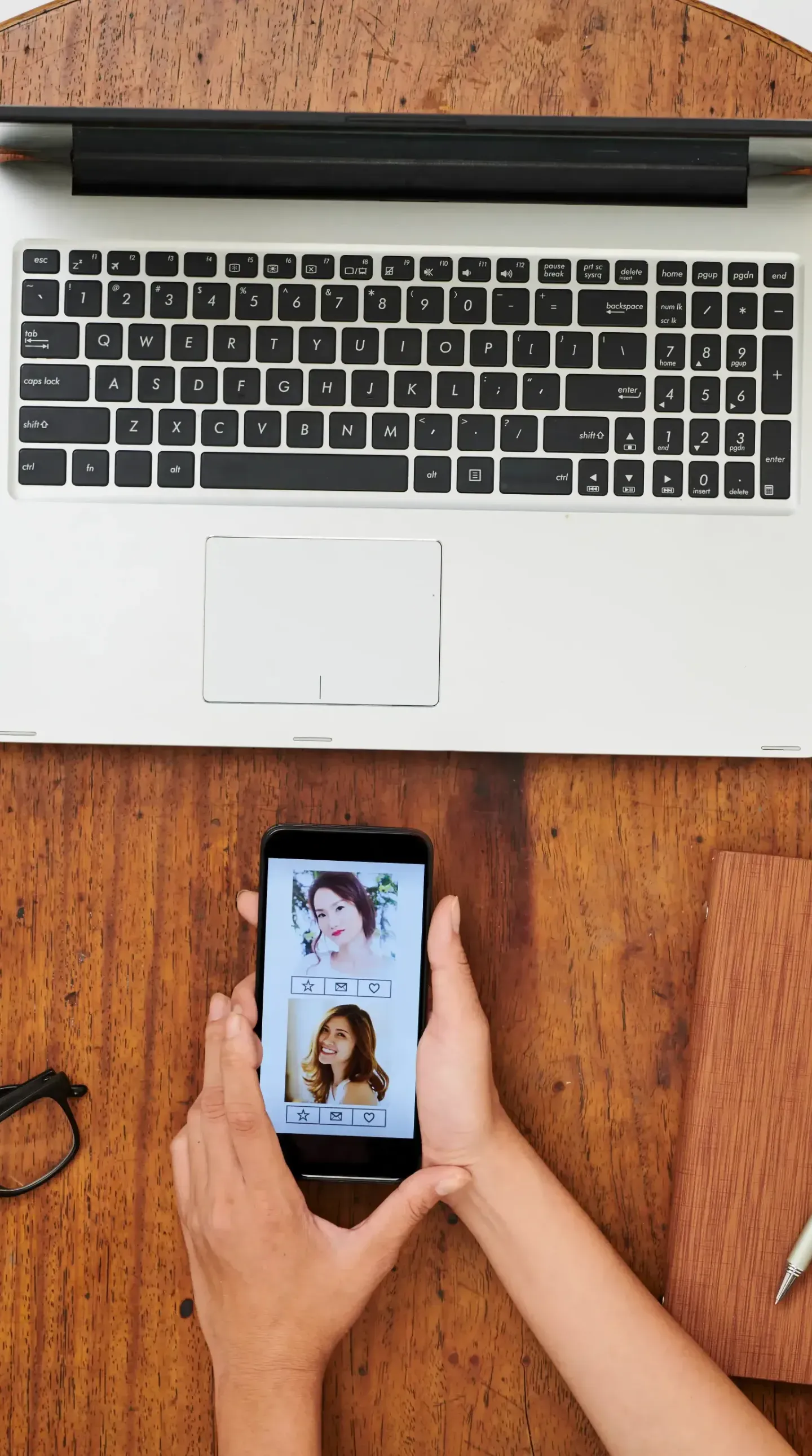 A person is holding a cell phone in front of a laptop on social media.