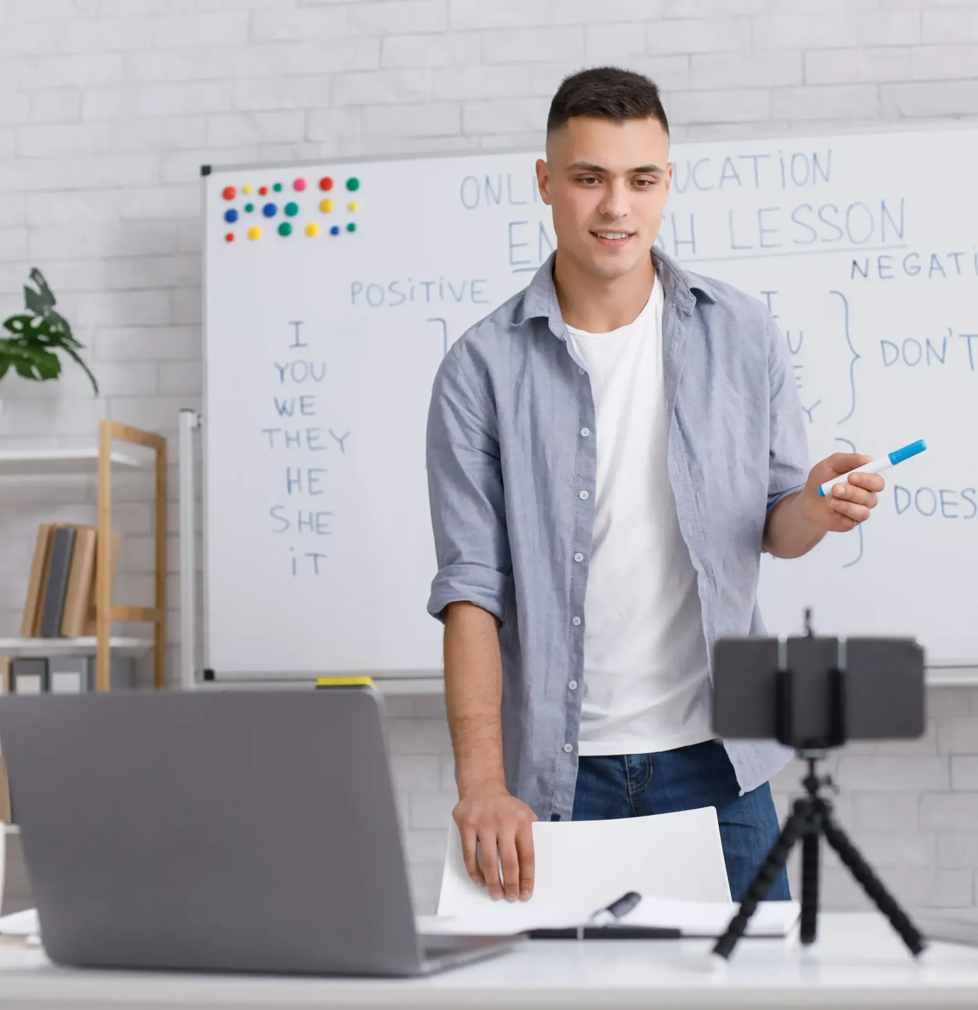 A man is standing in front of a white board teaching a masterclass.
