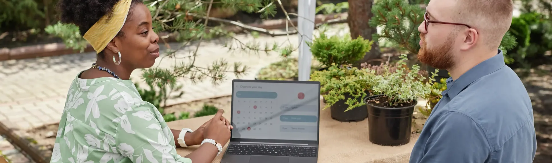 A man and a woman are looking at a laptop computer.