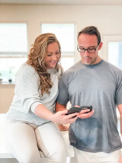 AP Digital Service Owners Amanda and Peter are looking at a cell phone together for SEO and evergreen content creation.