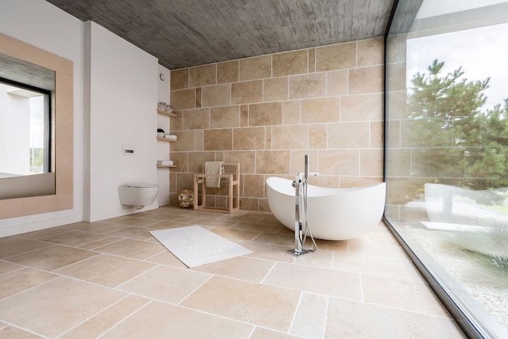 Bathroom with large mirror and beige tiles