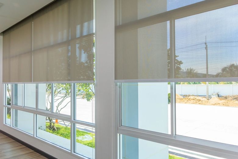 A room with a lot of windows and blinds on them.