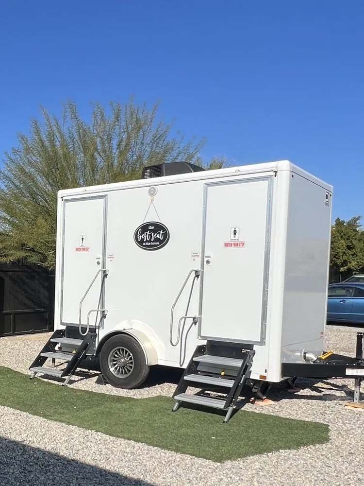 White portable restroom trailer with two separate entrances.