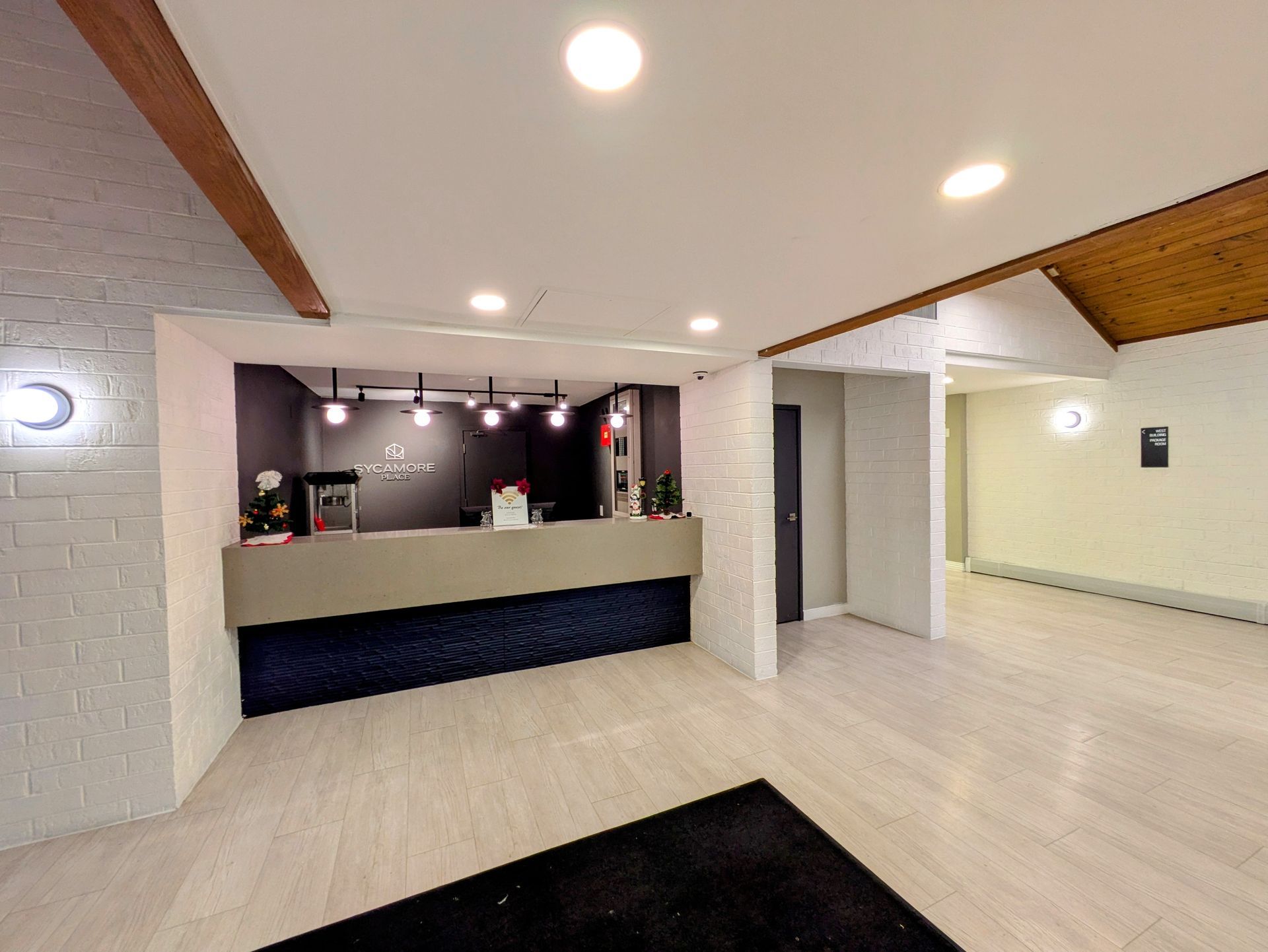 A hotel lobby with a reception desk and a black rug