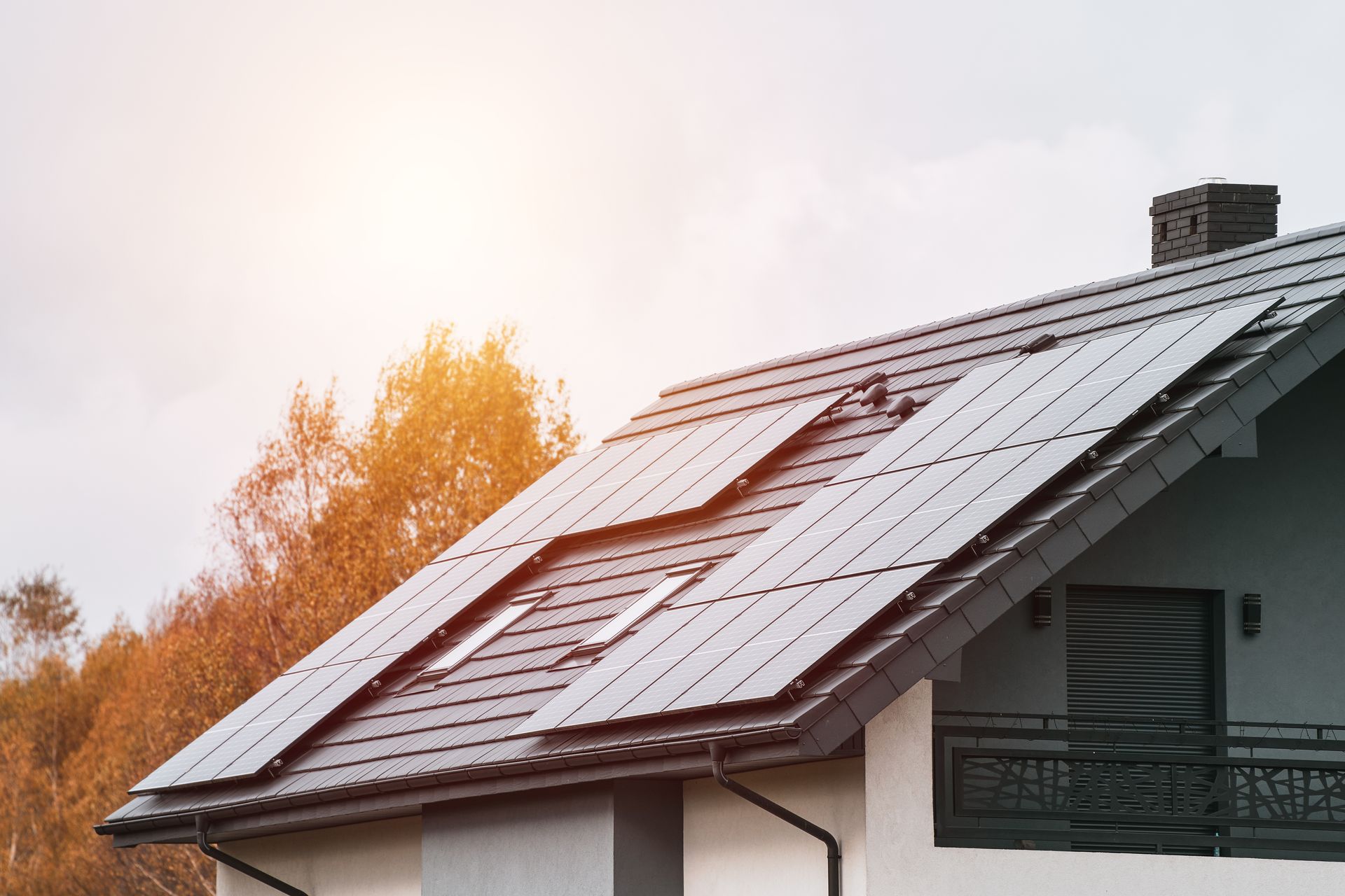 Modern home roof with cleanly installed solar panels against an overcast sky, illustrating residential clean energy generation.