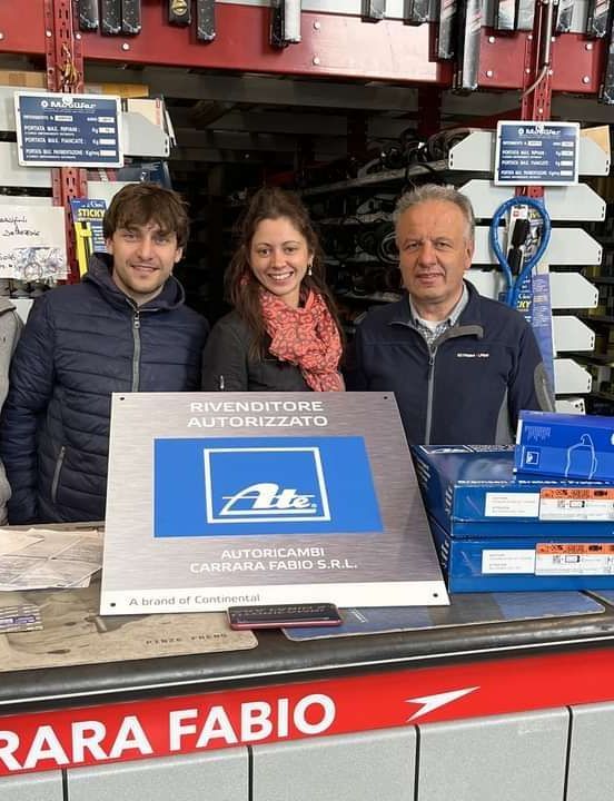 Un cane nell'ambulatorio del veterinario osserva un veterinario in camice blu che esamina una radiografia, probabilmente sul lettino.