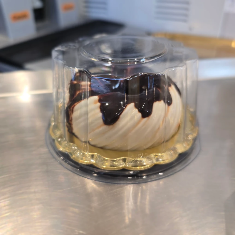 Una torta in un contenitore di plastica su un tavolo