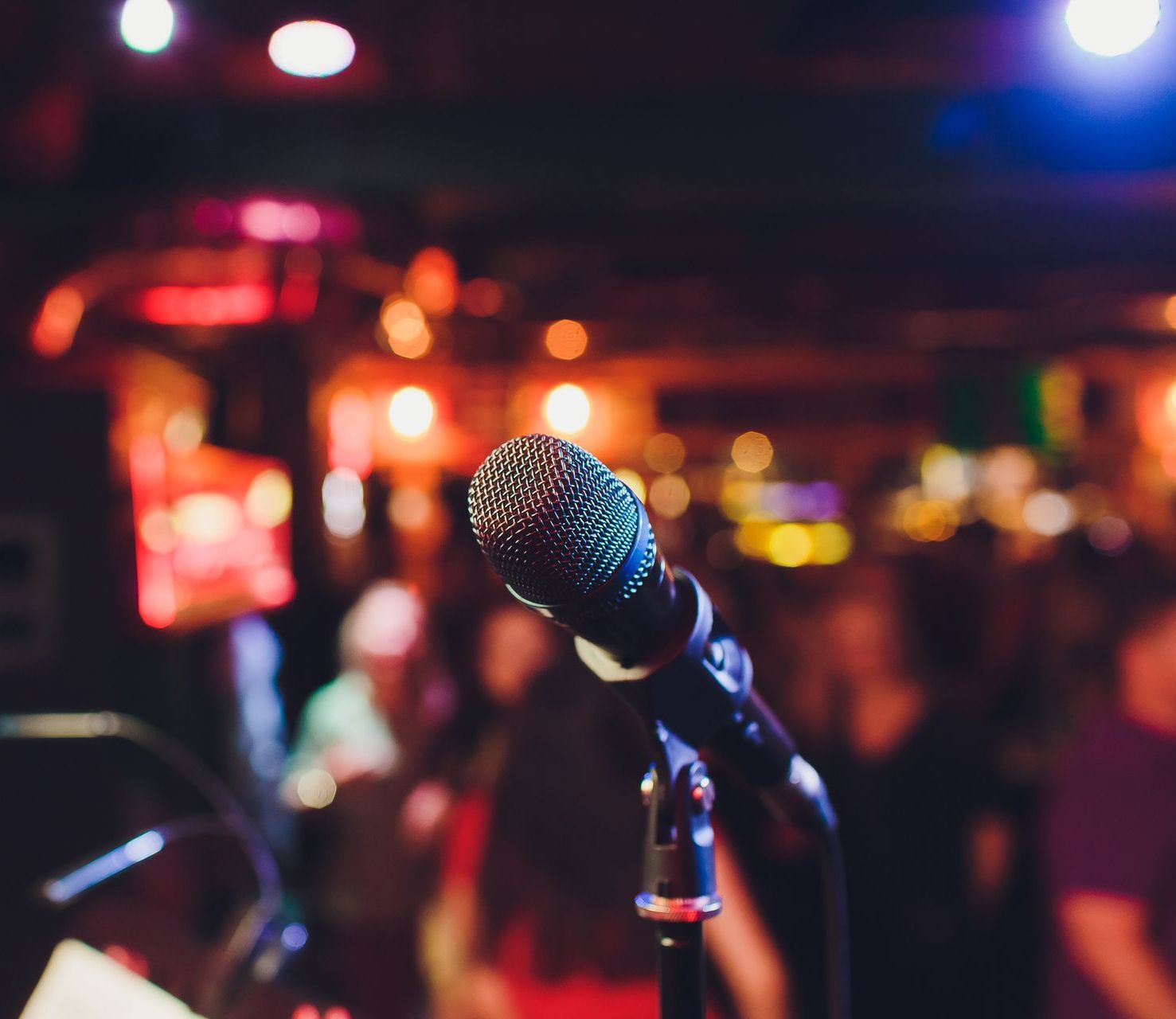 Un microfono è posizionato su un supporto di fronte a una folla.
