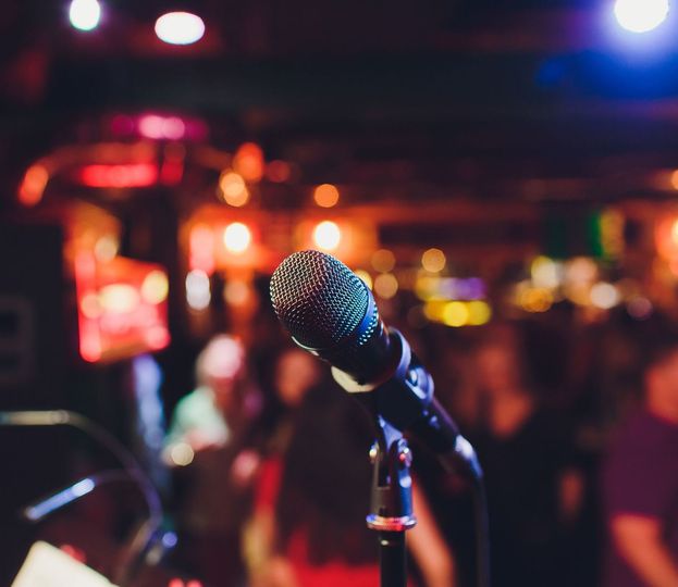 Un microfono è posizionato su un supporto di fronte a una folla.