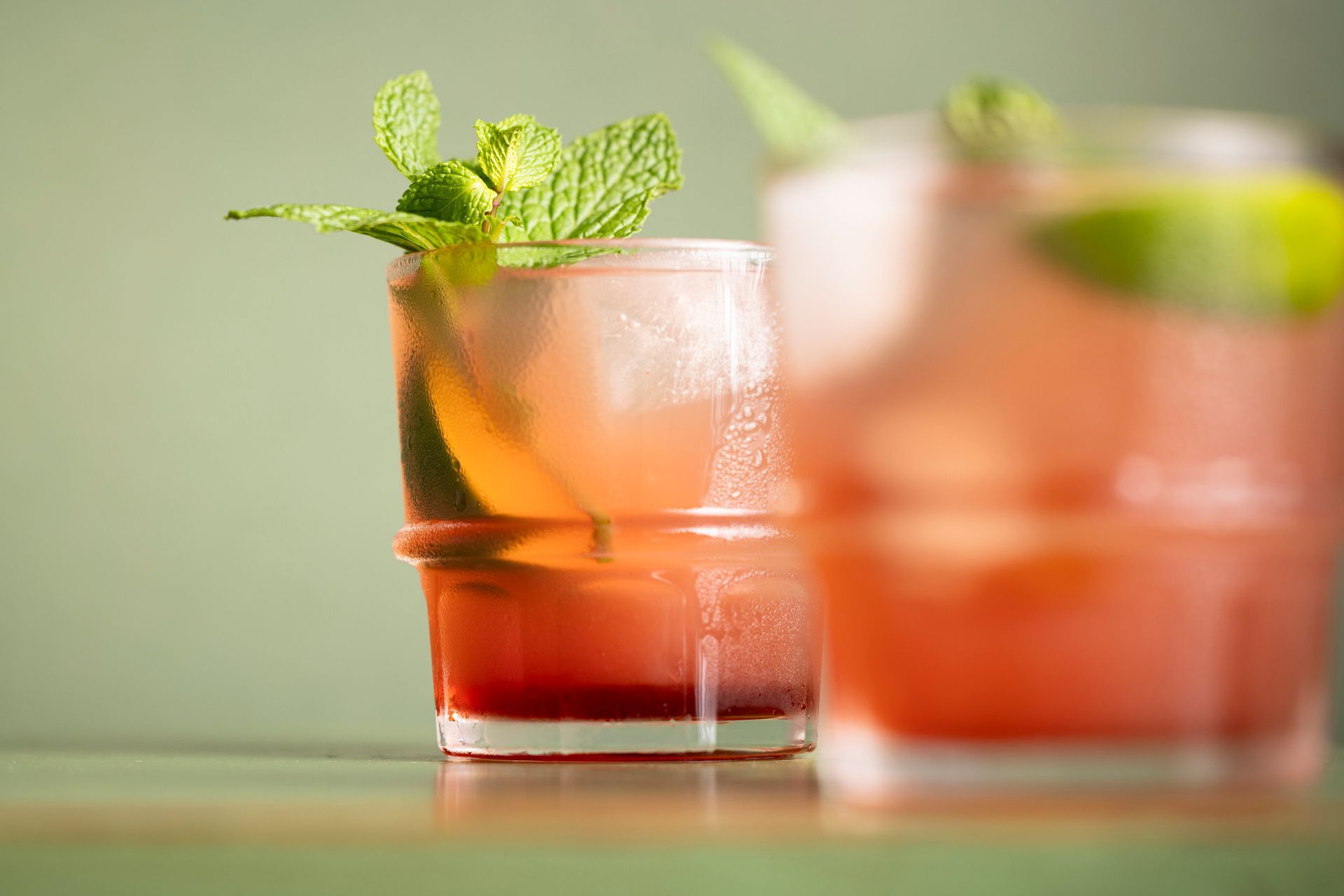 Due bicchieri di cocktail con foglie di menta su un tavolo.
