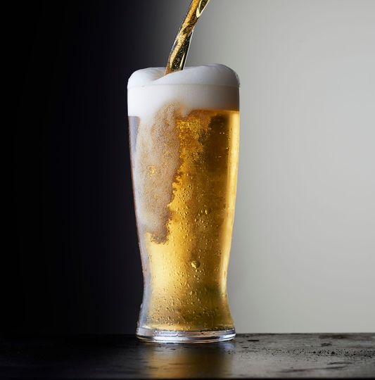 Un bicchiere di birra viene versato su un tavolo