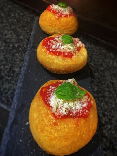 Una fila di ciambelle di pizza con salsa di pomodoro e formaggio