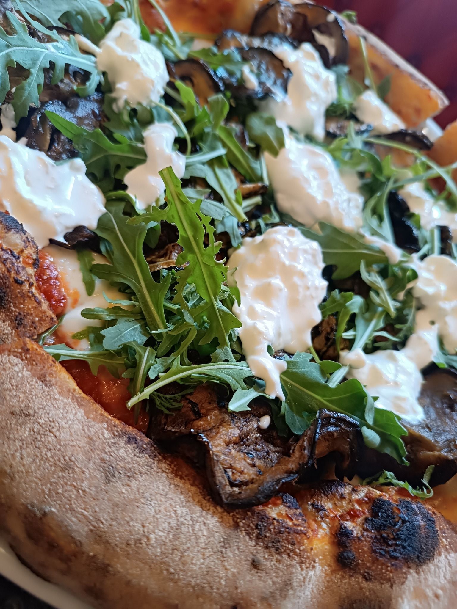 Una pizza con tanti condimenti è su un piatto.