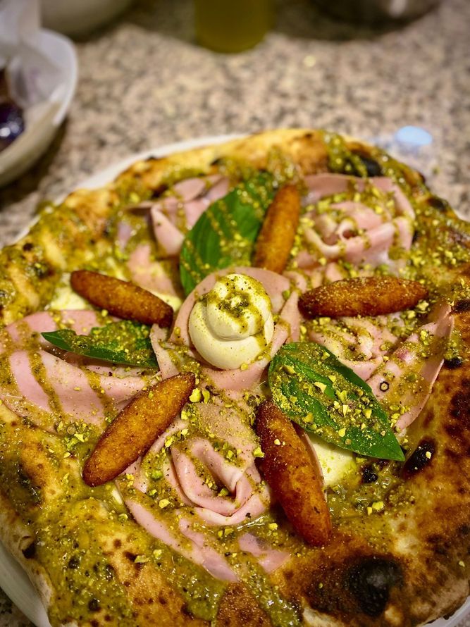 Una pizza con tanti condimenti è su un piatto su un tavolo.