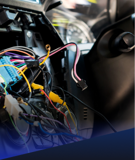 A close-up of a vehicle dashboard interior with exposed, multicolored electrical wiring and disconnected connectors. | Heaven Sent Automotive