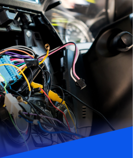 A close-up of a vehicle dashboard interior with exposed, multicolored electrical wiring and disconnected connectors. | Heaven Sent Automotive