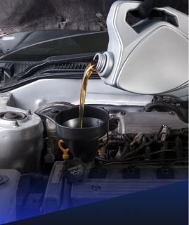 Someone pouring golden motor oil from a gray container into an engine through a black funnel. | Heaven Sent Automotive