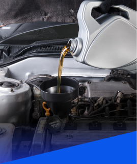 Someone pouring golden motor oil from a gray container into an engine through a black funnel. | Heaven Sent Automotive