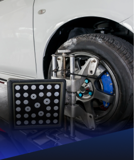 A wheel alignment target mounted to a car wheel in an automotive shop. | Heaven Sent Automotive