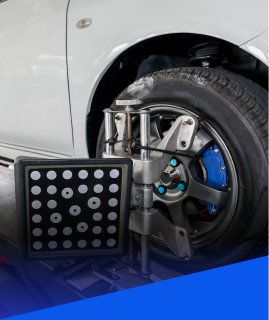 A wheel alignment target mounted to a car wheel in an automotive shop. | Heaven Sent Automotive