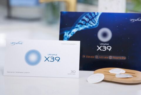 Two boxes of Lifewave X39 patches with patches on a wooden tray. Blue and white packaging.