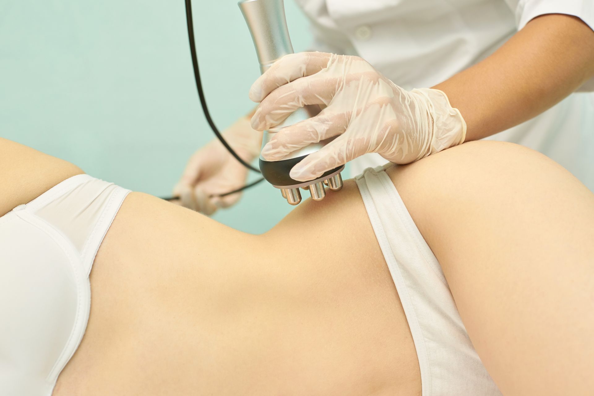 Therapist using a handheld device on a person’s lower back during a treatment session
