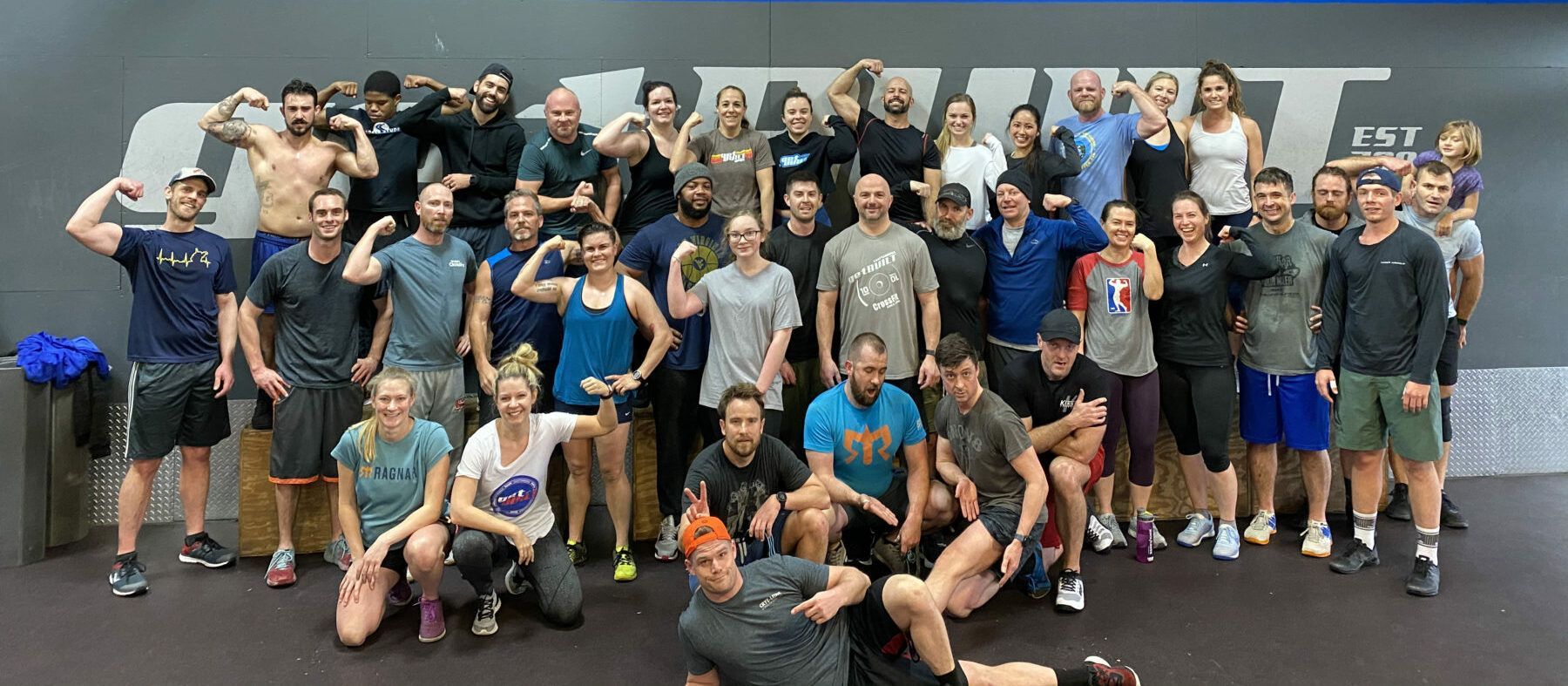A large group of people are posing for a picture in a gym.