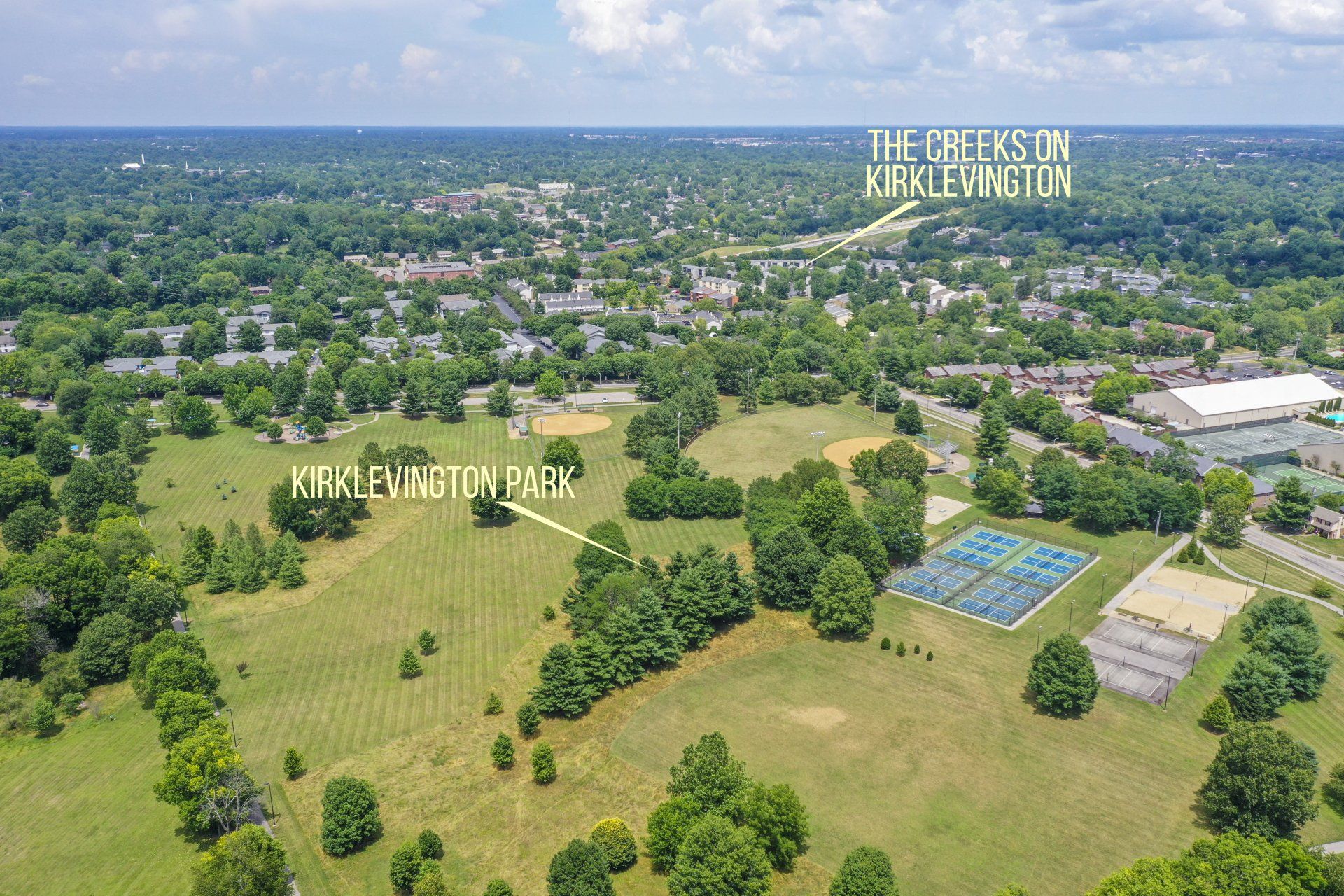 An aerial view of a park with trees and a tennis court The Creeks on Kirklevington.
