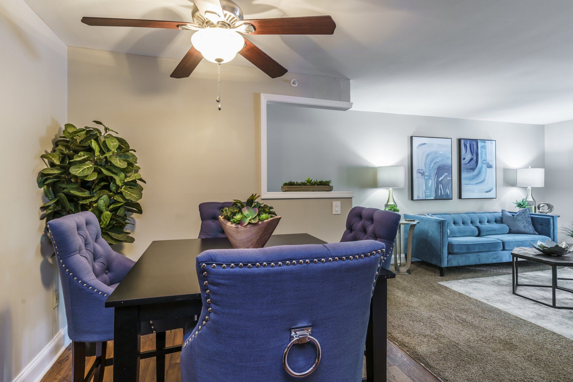 A dining room with a table and chairs and a ceiling fan