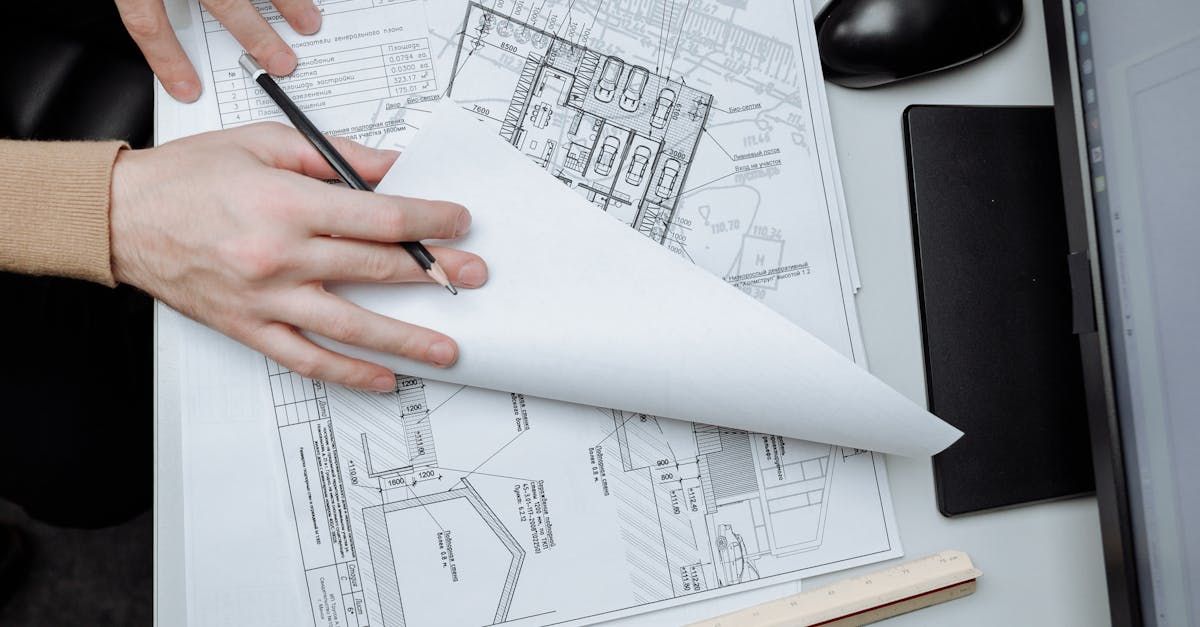 A person is holding a pencil over a piece of paper.