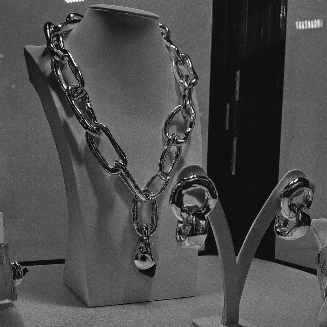 Collana d'argento e orecchini coordinati esposti su manichini in una gioielleria.