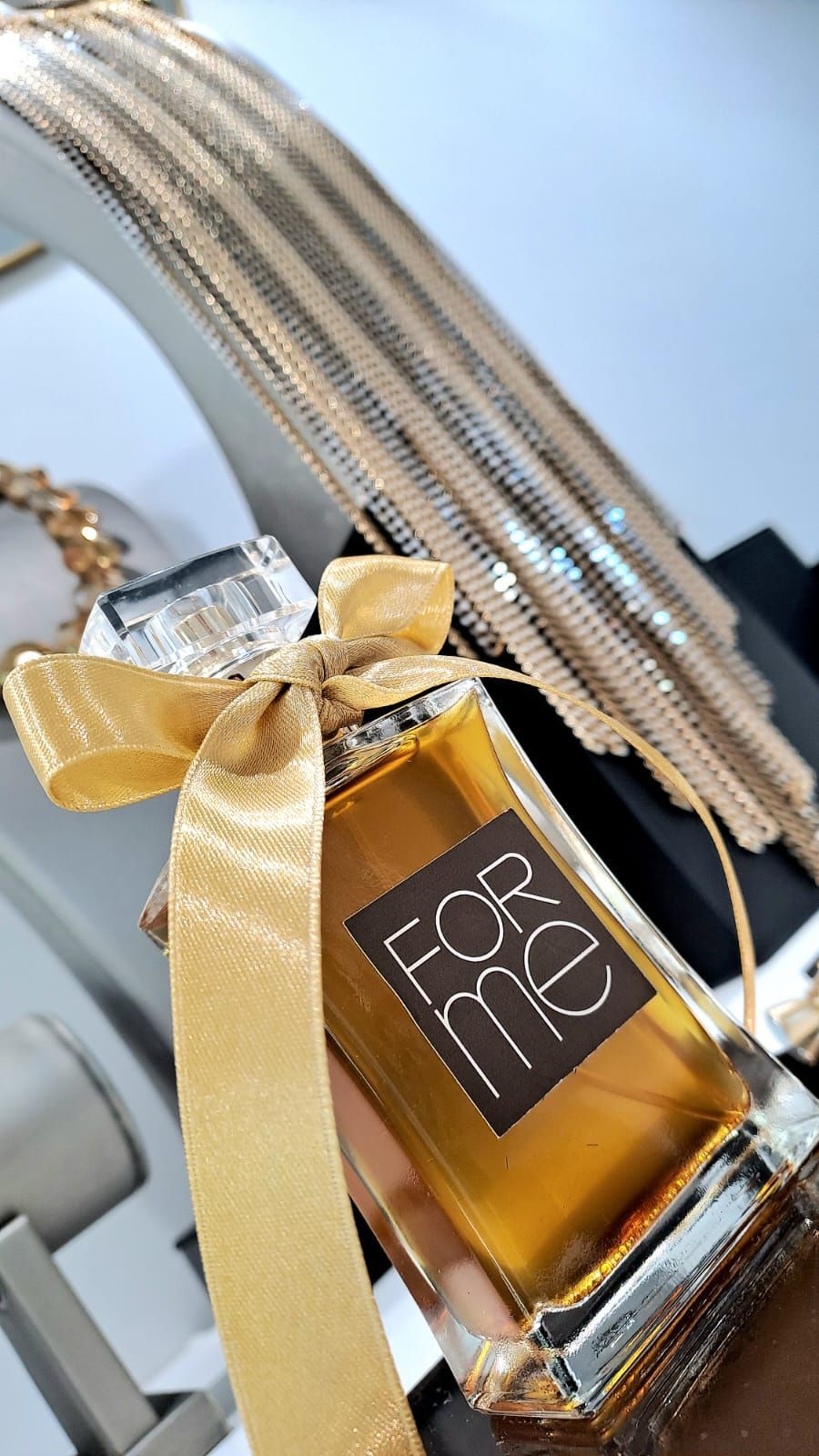 Un primo piano di una bottiglia di profumo con un fiocco.