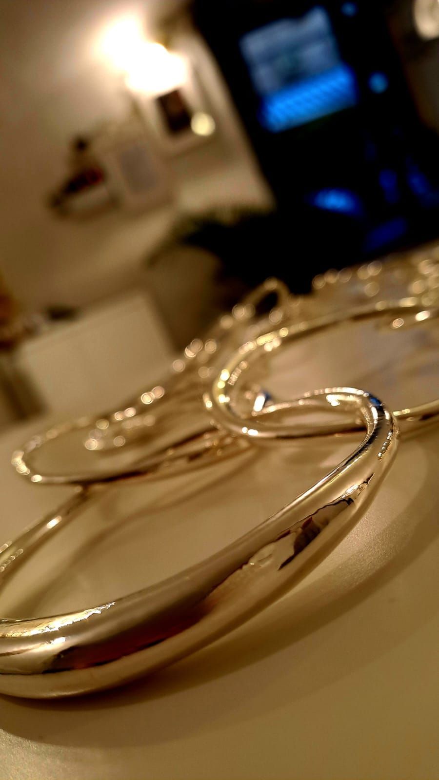 Primo piano di un paio di orecchini a cerchio d'argento su un tavolo.