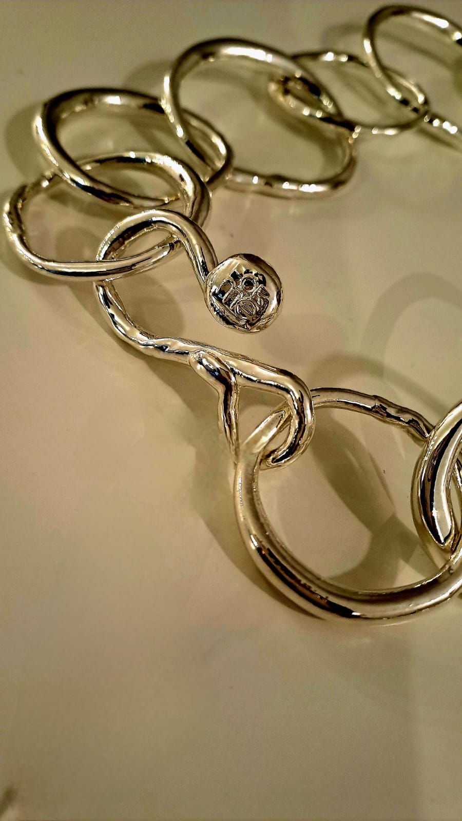 Un primo piano di una collana d'argento con un diamante al centro