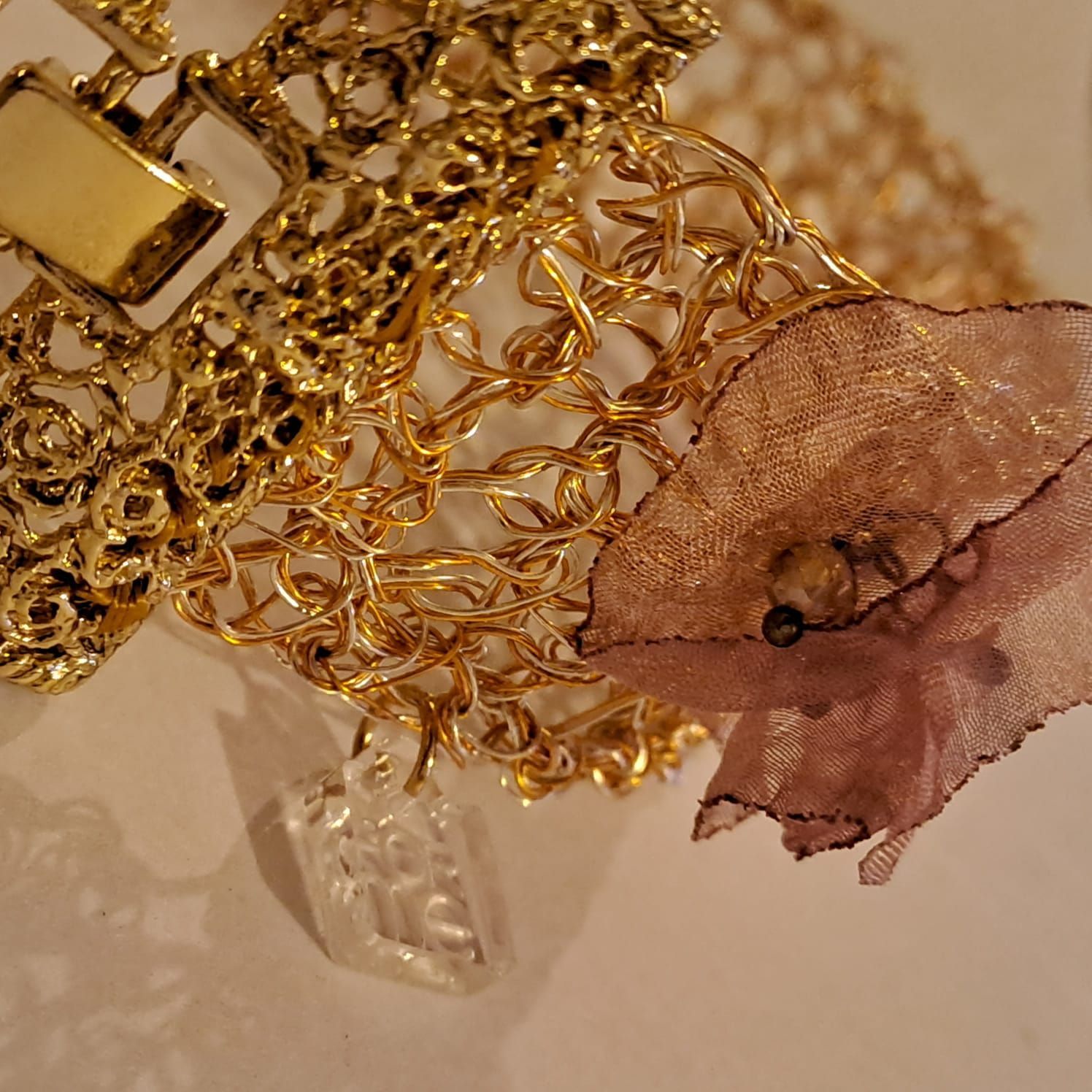 Un primo piano di una collana d'oro con un ciondolo a forma di fiore