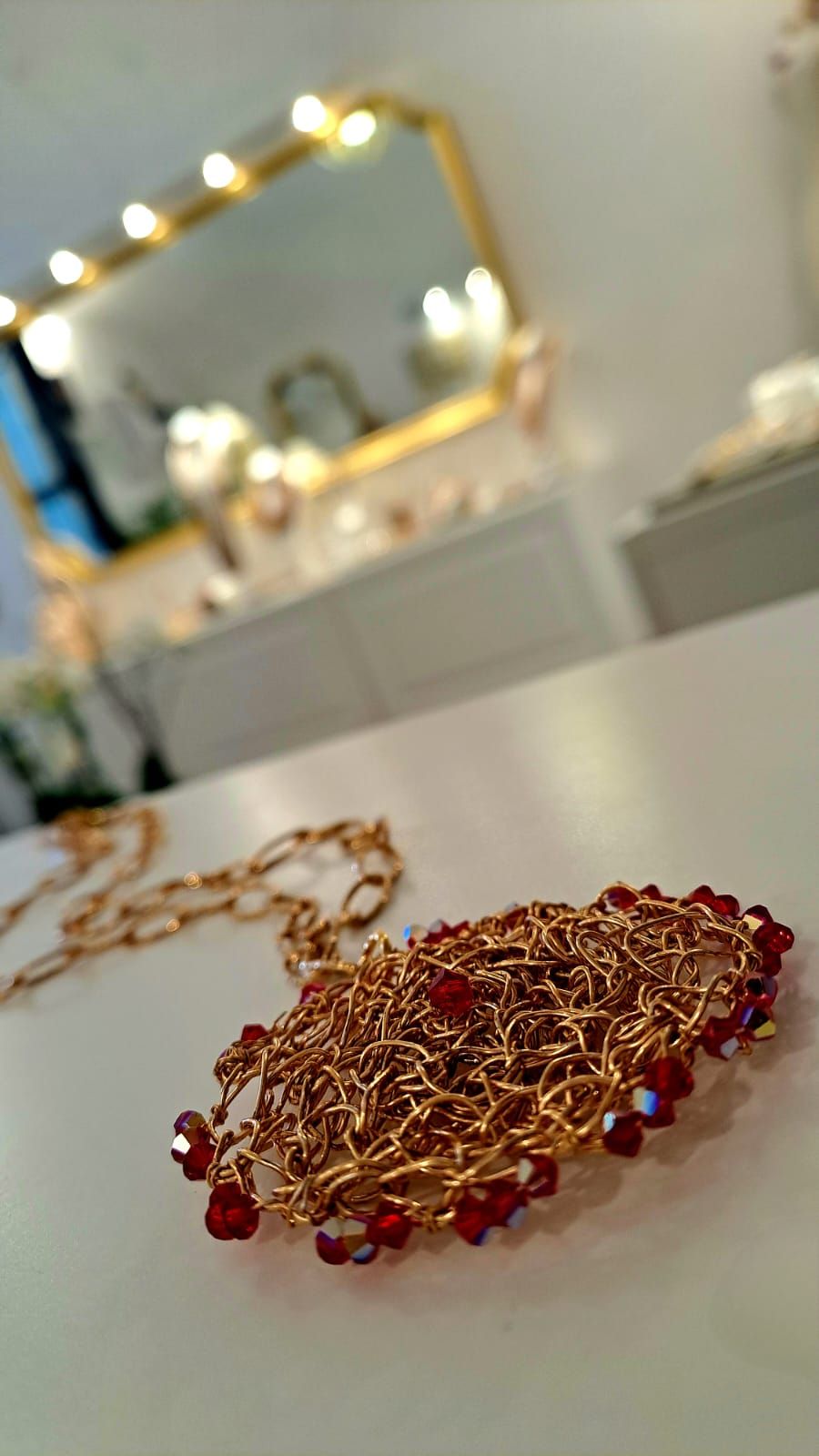 Primo piano di una collana con perline rosse su un tavolo.