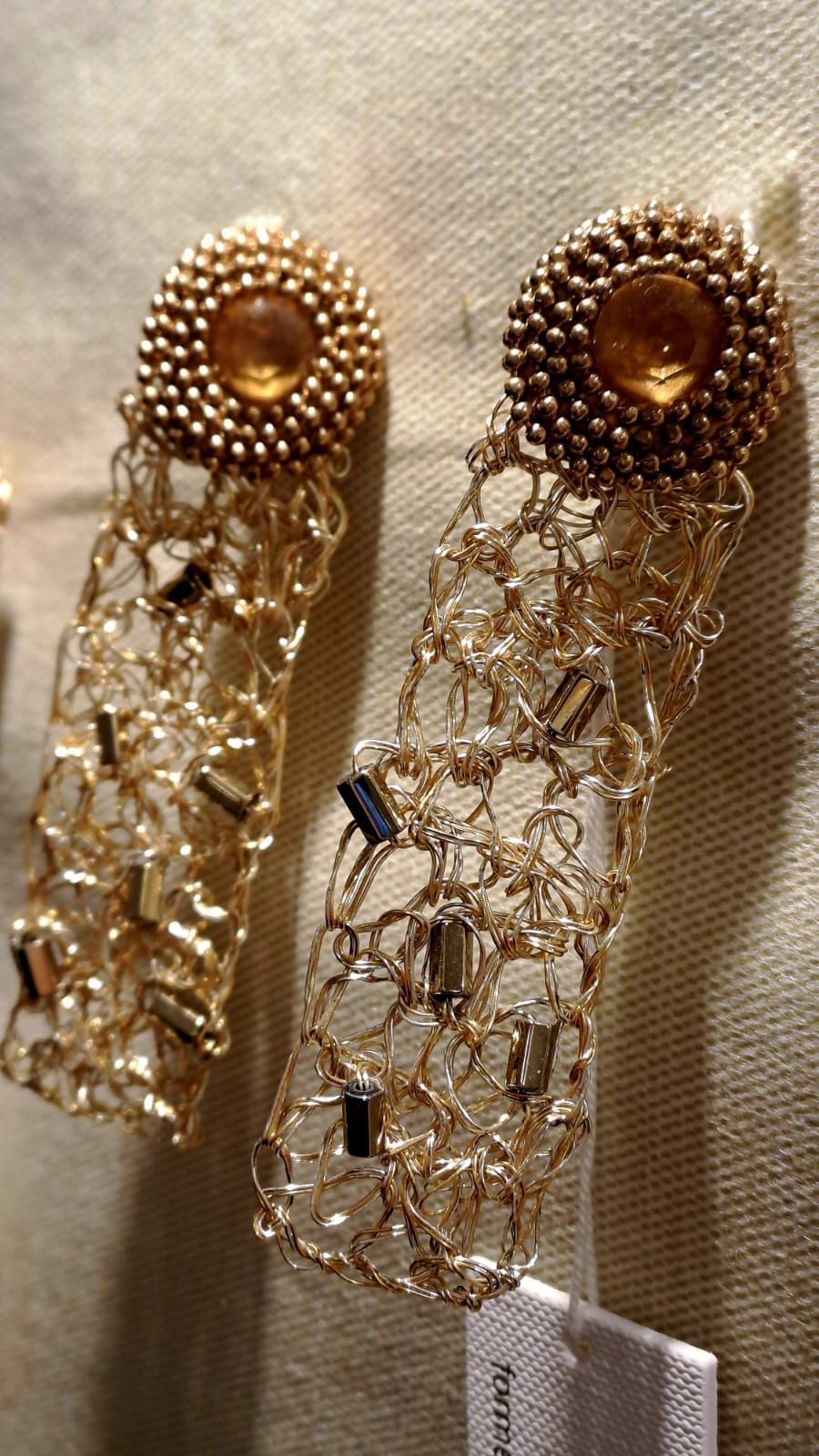 Un paio di orecchini d'oro sono appoggiati su un tavolo.