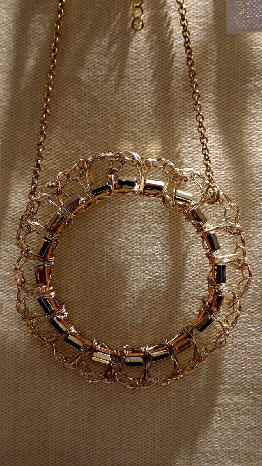 Primo piano di una collana con un pendente a forma di cerchio su una catena.