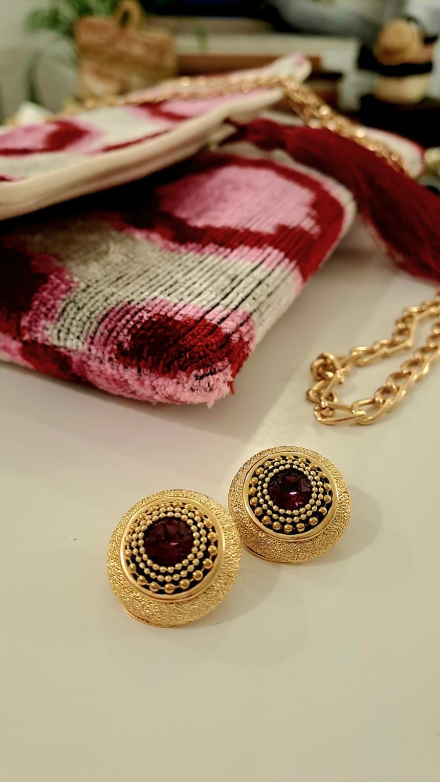 Un paio di orecchini sono appoggiati su un tavolo accanto a una borsa.