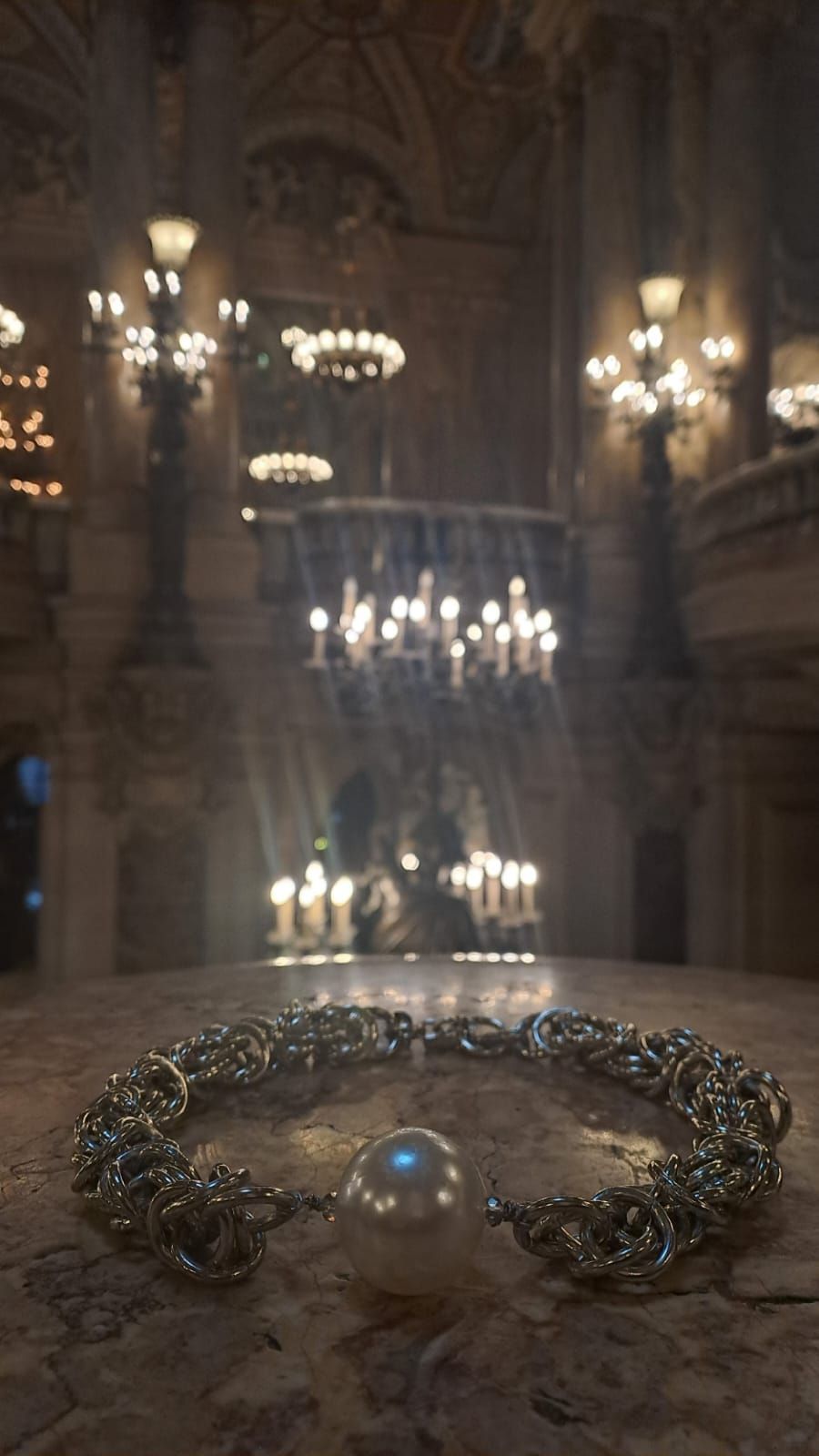 Una perla è appoggiata su un tavolo in una stanza con delle candele.