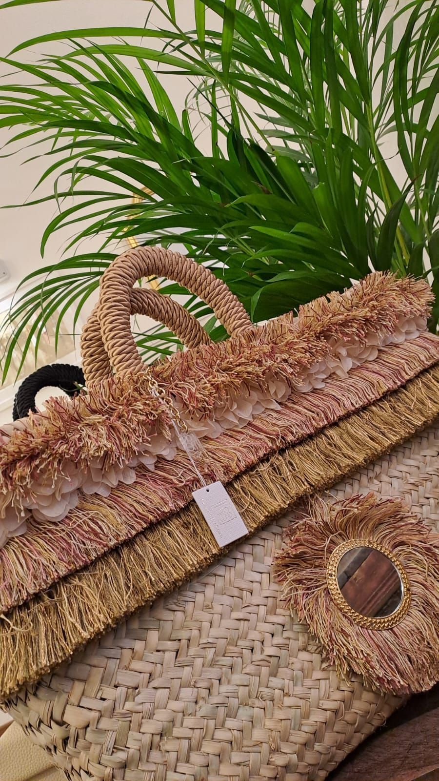 Un cesto di vimini è appoggiato su un tavolo di legno accanto a una palma.