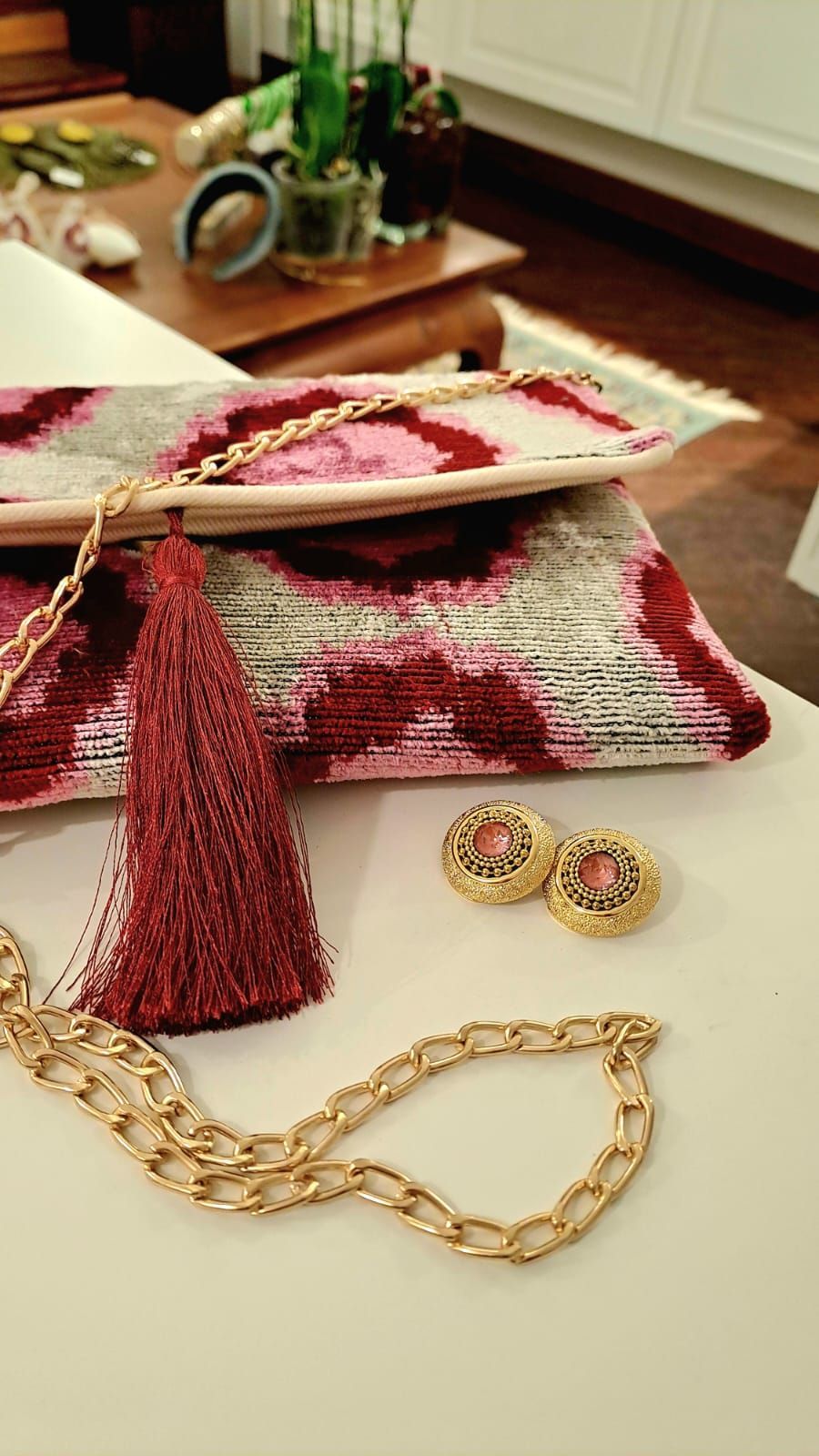 Una borsa, degli orecchini e una collana sono su un tavolo.