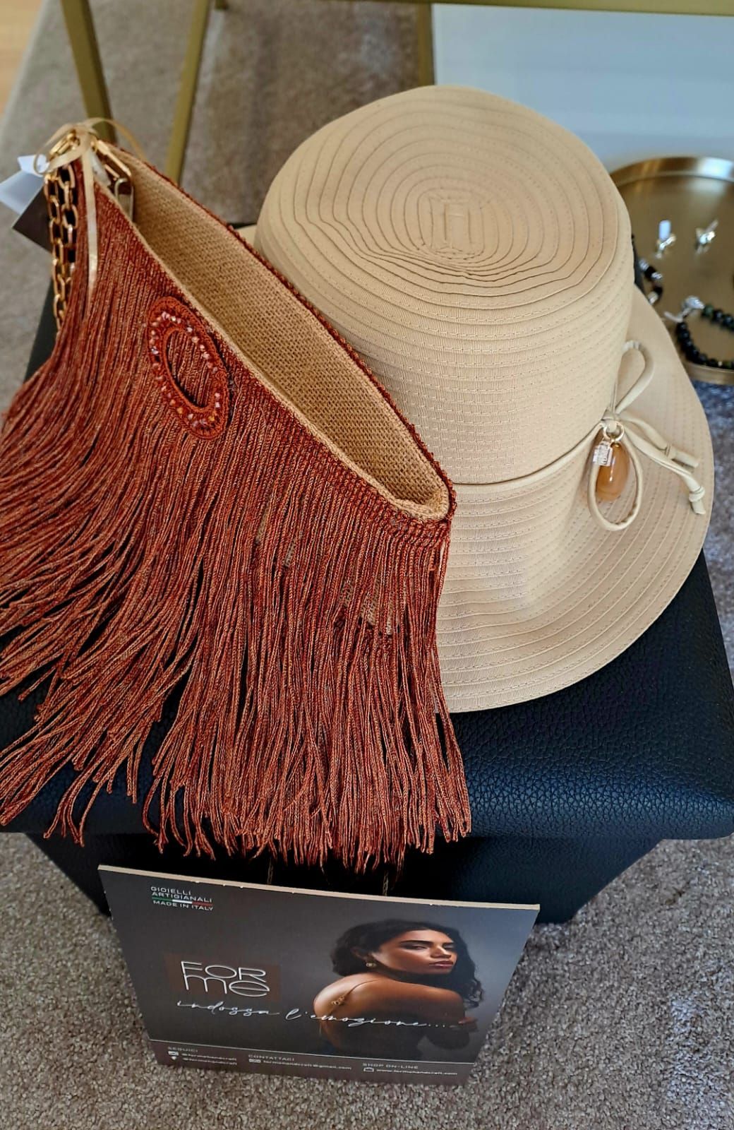 Un cappello e una borsa con le frange sono su un tavolo.