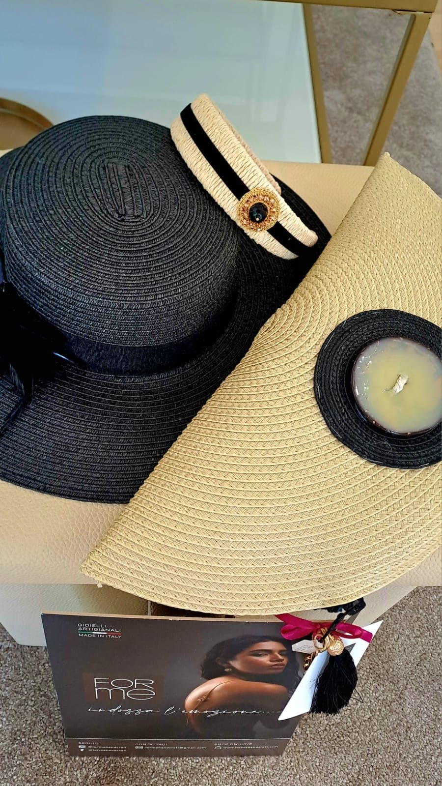 Un cappello e una borsa sono appoggiati su un tavolo accanto a una candela.