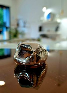 Primo piano di un anello d'argento su un tavolo.