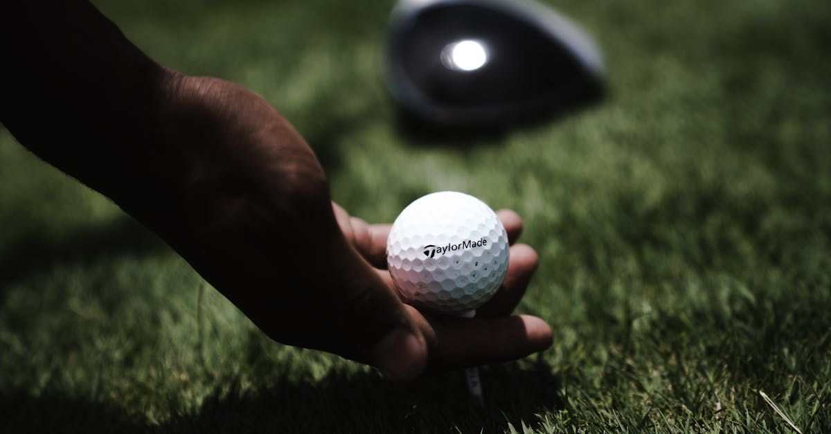 A person is putting a golf ball on a tee.